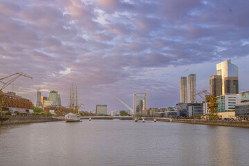 .sunset in city with river, buildings and boats