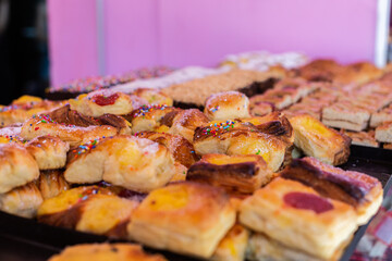 Close up freshly baked pastry goods on display in bakery shop. Selective focus