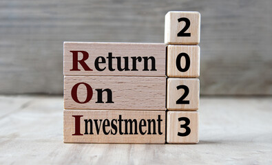 RETURN ON INVESTMENT 2023 - words on wooden blocks on gray background