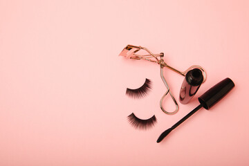 Composition with false eyelashes, mascara and eyelash brushes, eyelash curlers on a pink background. Makeup artist tools. Beauty concept. Makeup. Place for text. Place for copying. Flatley. MOCAP.