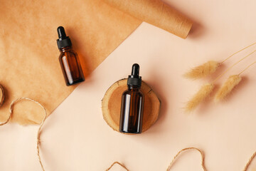 Two glass amber bottles with black cap flat lay. DIY scene. Beauty products packaging scene. Dropper bottle with pipette on wooden podium. Natural eco-friendly cosmetics presentation with copy space