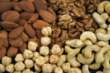 background from different types of nuts. almonds, cashews, hazelnuts and walnuts.