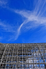 Dichotomy. Wispy clouds and rigid metal structure 
