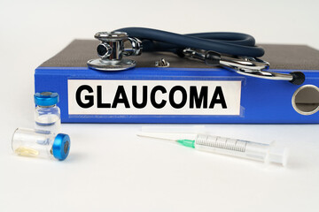 On a white surface, a syringe, a stethoscope and a folder with the inscription - Glaucoma