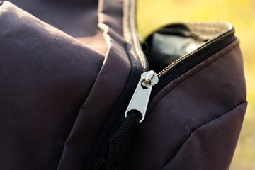 Lightning closure of an open backpack bag outdoors.