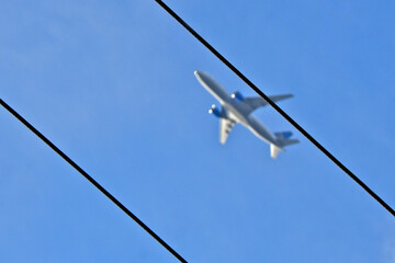 Shallow Depth of field. Using a wide aperture with sharp focus on power lines will blur background