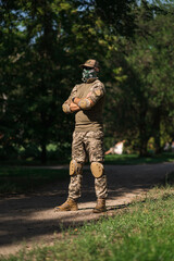 Soldier in protective uniform. Protective camouflage uniform. Elbow pads and knee pads for soldiers