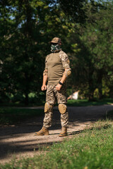 Soldier in protective uniform. Protective camouflage uniform. Elbow pads and knee pads for soldiers