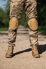 Soldier in protective uniform. Protective camouflage uniform. Elbow pads and knee pads for soldiers