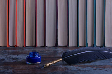A beautiful black nib for writing and calligraphy and a bottle of blue ink on a vintage wooden...