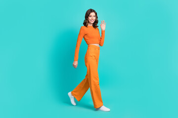 Fototapeta na wymiar Full length photo of positive adorable lady dressed trendy clothes moving empty space isolated on cyan color background