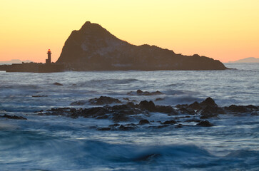 Lighthouse and islet at sunset in Utoro. Shiretoko Peninsula. Hokkaido. Japan.