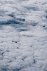 Airplane in the sky in the clouds, vertical photo from the porthole