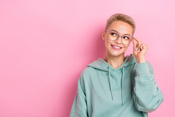 Photo portrait of attractive young woman look interested empty space eyewear dressed stylish khaki outfit isolated on pink color background