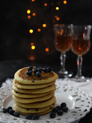 Pancakes with blueberries on dark background with bokeh