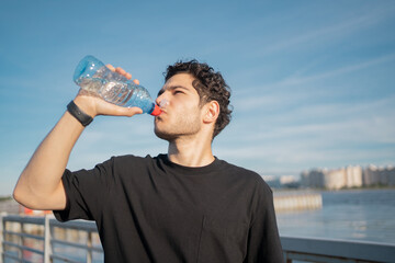 A bottle of pure water a man drinks thirst during a sports workout.