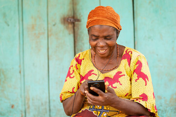 excited old african woman using her phone, listening to music