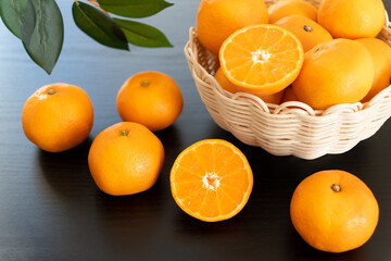 半分にカットしたみかんとたくさんのみかん