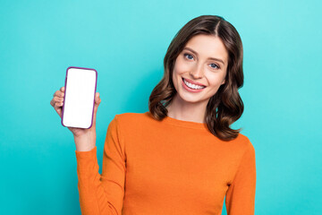 Photo of adorable cheerful lady hand hold gadget presenting empty space new iphone app isolated on cyan color background