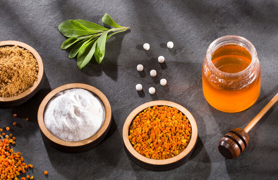 Top view of natural sweeteners - Sugar, stevia leaves, pollen and honey.