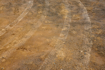 Tire tread marks on the ground as a backdrop.