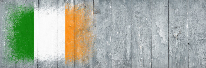 Flag of Ireland. Flag is painted on a gray wooden plank surface. Wooden background. Plywood surface. Copy space. Textured background