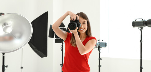 Young female photographer with modern equipment in studio