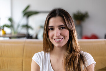 Close up portrait of smiling young adult pretty woman looking at camera. Millennial female with...