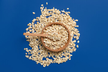 Plate of raw oatmeal on blue background