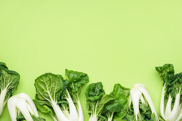Fresh pak choi cabbages on green background - obrazy, fototapety, plakaty