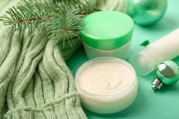 Fototapeta na wymiar Cosmetic products, sweater and fir branch on color background, closeup