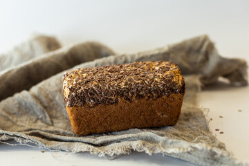 bread with seeds lying on the board, photo in the style of rustic, on a grey background, a place for text