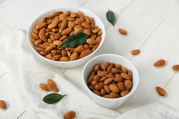 Bowls of almonds on white wooden table