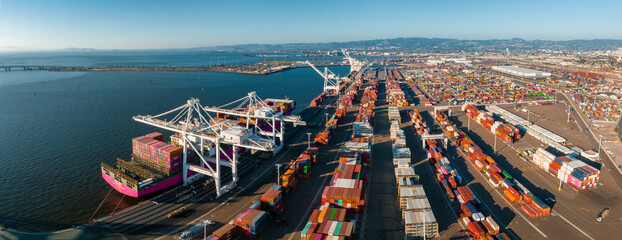 The Oakland Outer Harbor aerial view. Loaded trucks moving by Container cranes. View of busy Port...