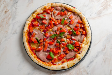 Italian meat pizza with roastbeef, tomatoes, basil and red onion on marble table top view
