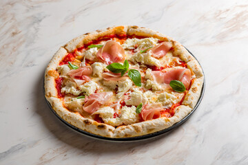 pizza with parma ham and cheese mozarella with basil on marble table