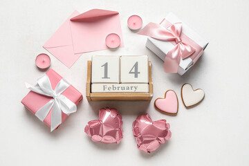 Cube calendar with date 14 FEBRUARY, gifts, cookies, envelopes and balloons on white background