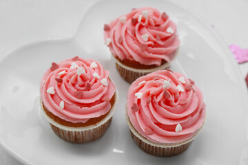 Plate with tasty cupcakes for Valentine's Day on white background, closeup
