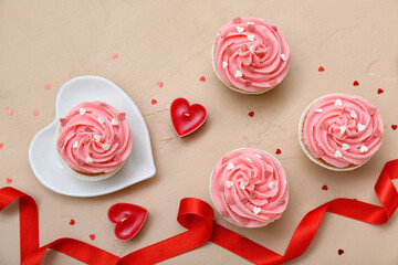 Plate with tasty cupcakes, candles and ribbon for Valentine's Day on beige background