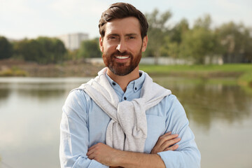 Portrait of handsome bearded man near lake