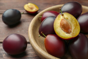 Tasty ripe plums on wooden table, closeup