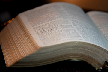 Fototapeta premium holy bible open on a wooden table with its left side slightly bent