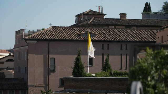 Vatican City flag in a rooftop of the city. No people slow motion shot 4K, Rome, Italy.