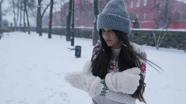 Woman feeling cold in park covered in snow with copy space