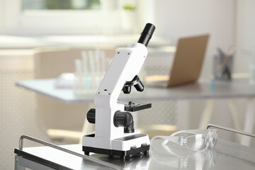 Modern medical microscope on metal table in laboratory