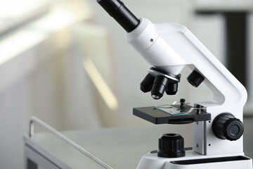 Fototapeta na wymiar Modern medical microscope on metal table in laboratory, closeup. Space for text