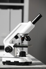 Modern medical microscope on table in laboratory