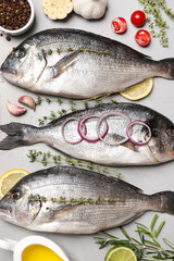 Flat lay composition with fresh raw dorado fish and ingredients on light grey table