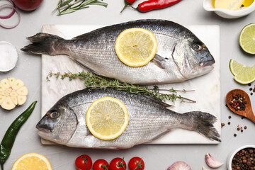 Flat lay composition with fresh raw dorado fish and ingredients on light grey table