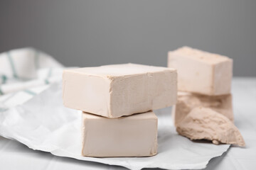 Blocks of compressed yeast on white table, closeup